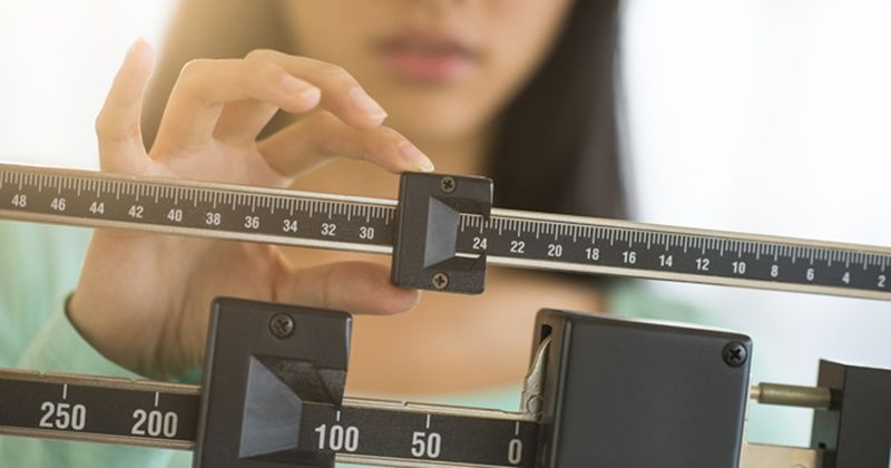 Woman checking her weight on a scale